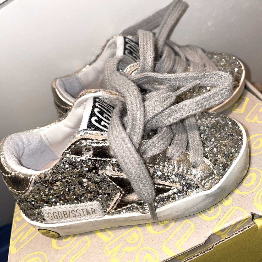 GOLDEN GOOSE
Baby gold Super-Star Sneakers. Glittered detailing throughout.